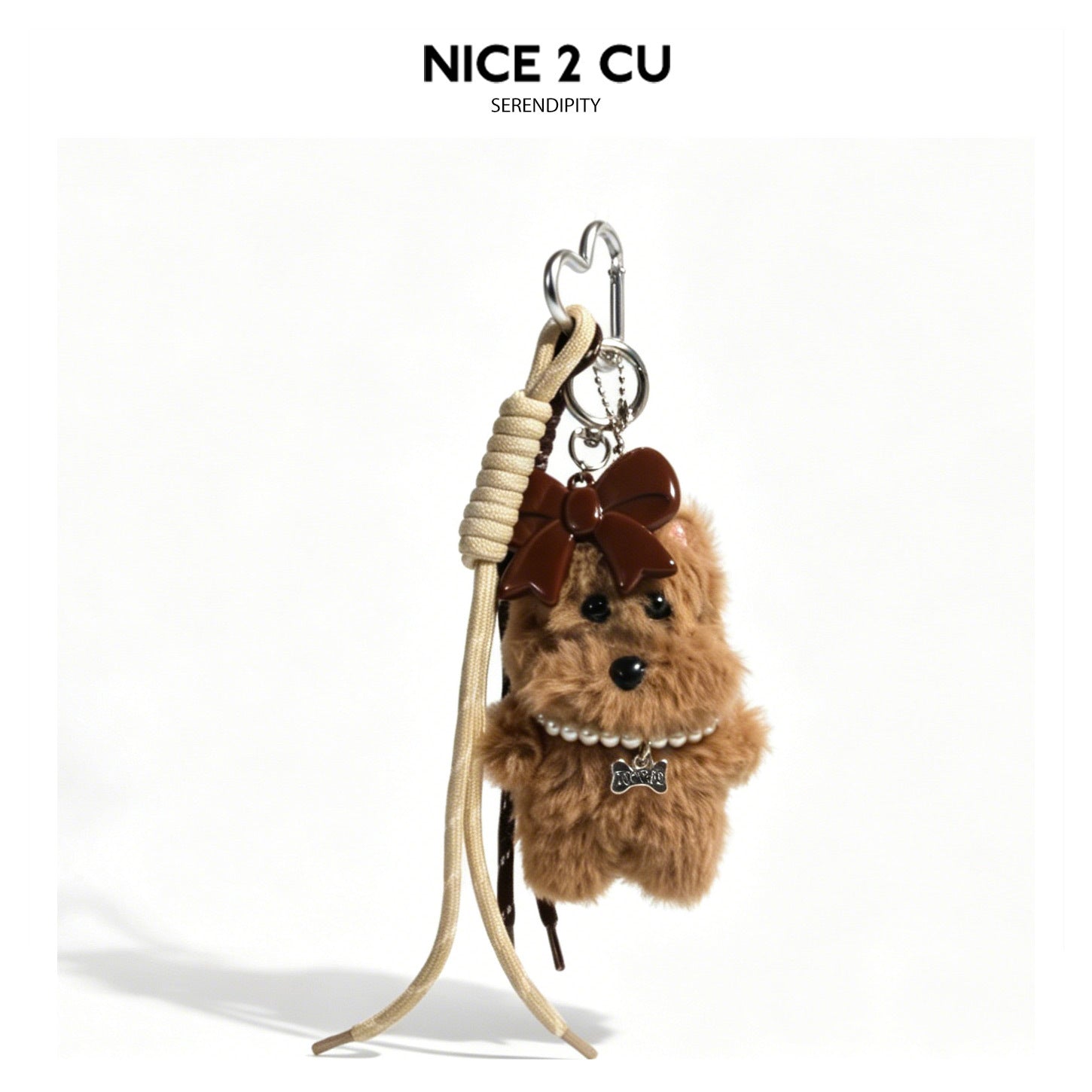 Brown fluffy dog bag charm with large bow, pearl-style necklace, and chocolate-bar pendant on heart-shaped silver carabiner