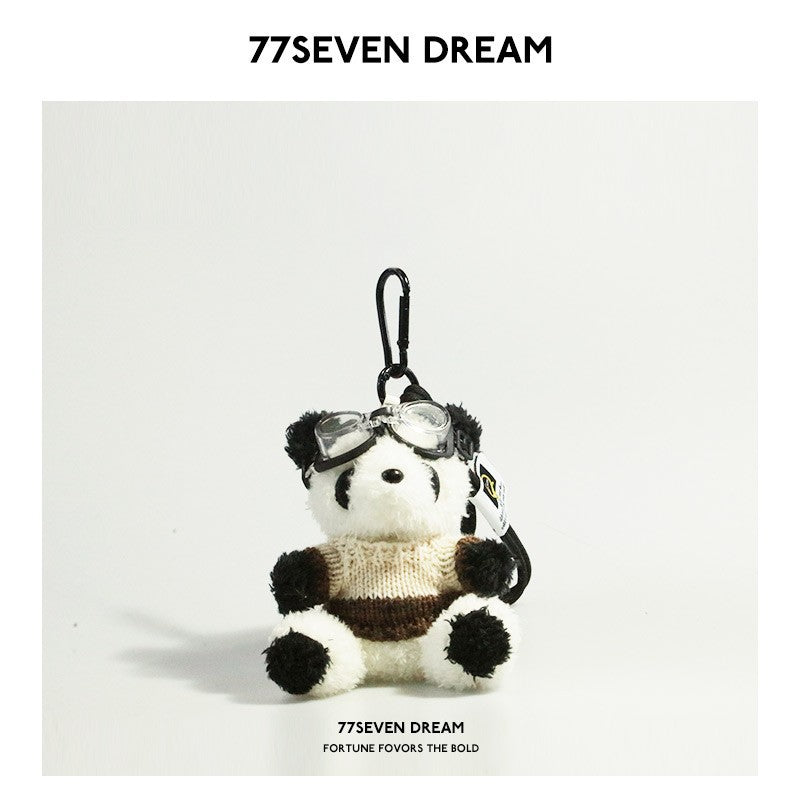 Seated panda plush charm with cream and coffee brown color-block knitted sweater and goggles