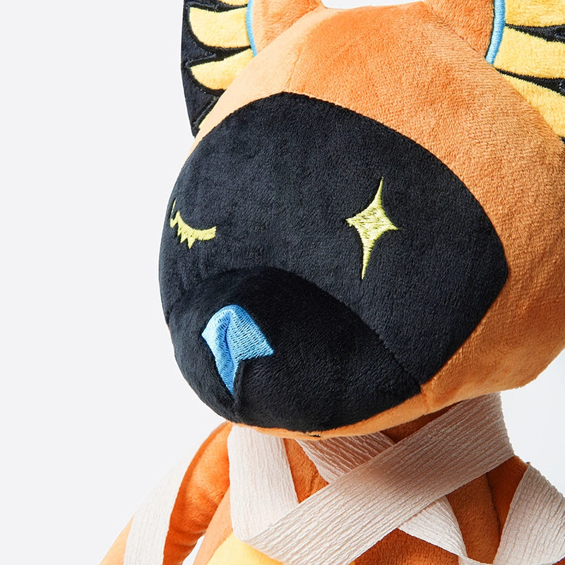The ZEIO Egyptian Cat Plush Toy features a black face, yellow star eyes, blue nose, orange body, and cream bandages on its neck and shoulders—a mystical stuffed animal inspired by mythology.