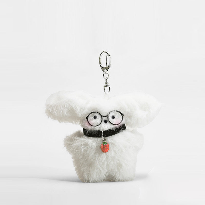 Fluffy white dog plush keychain charm with round black glasses and strawberry-shaped pendant