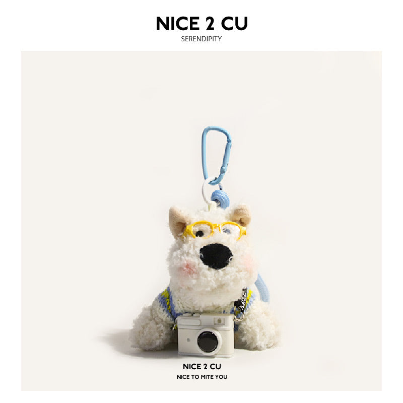 White Westie plush keychain with yellow glasses and blue-yellow sweater holding white camera, blue carabiner clip