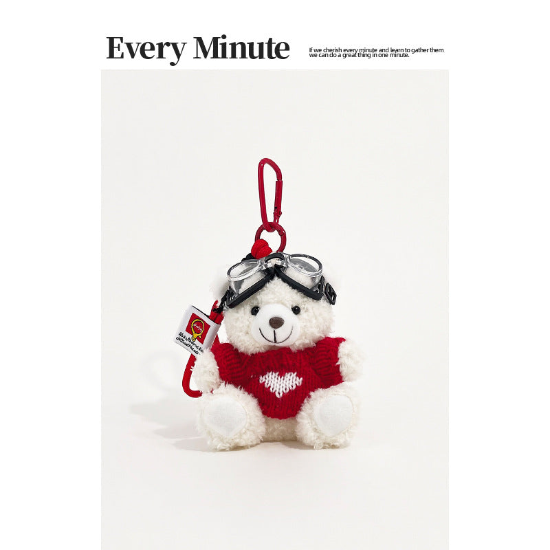 White bear plush keychain charm wearing aviator goggles and a red sweater with white heart motif and red carabiner clip