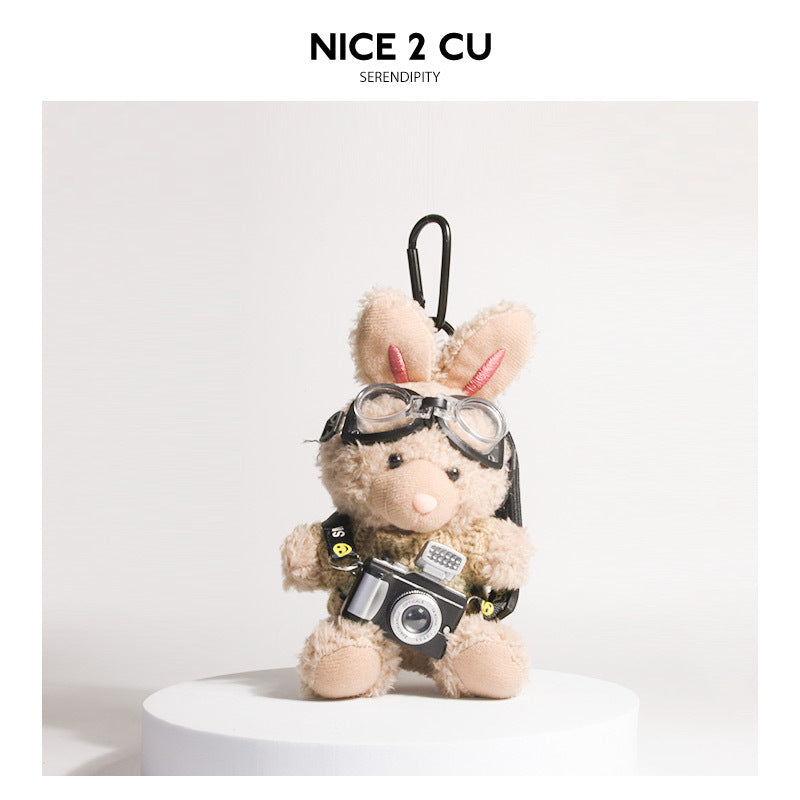 Brown plush rabbit keychain wearing khaki knit sweater with goggles and small camera pendant