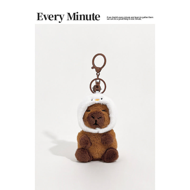 Brown plush capybara keychain wearing a white chick hood with orange beak detail and metal clip
