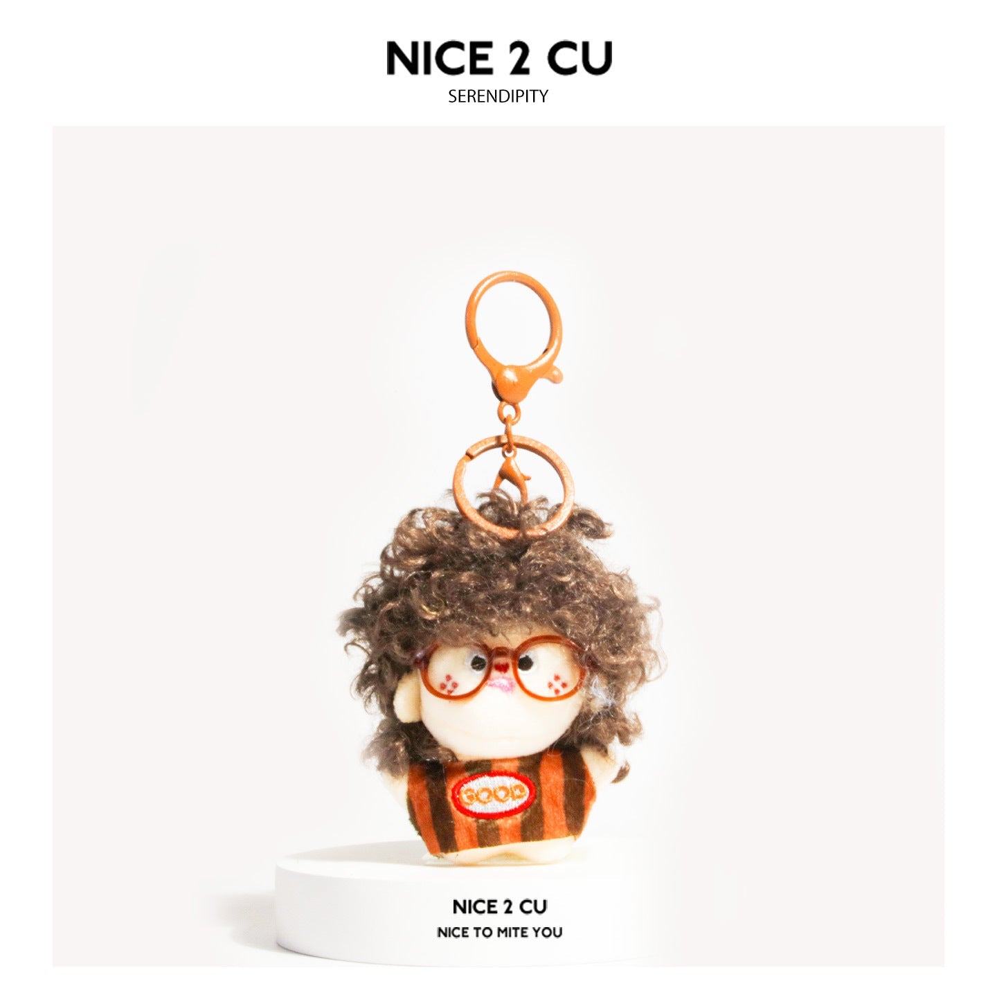 Dark brown curly-hair plush doll keychain with orange glasses and GOOD patch, brown-orange striped outfit, orange clasp