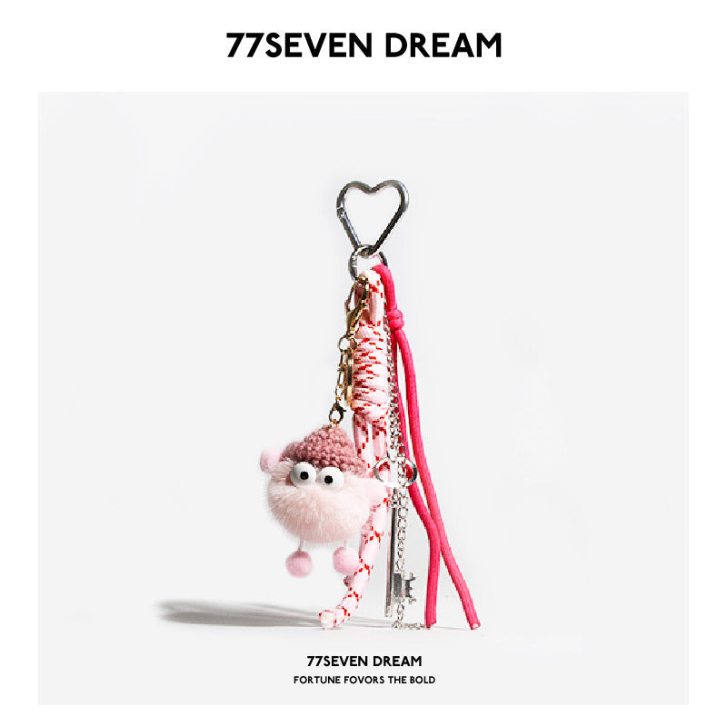 Pink fluffy plush monster bag charm with heart-shaped silver clip and pink-red braided cord lanyard