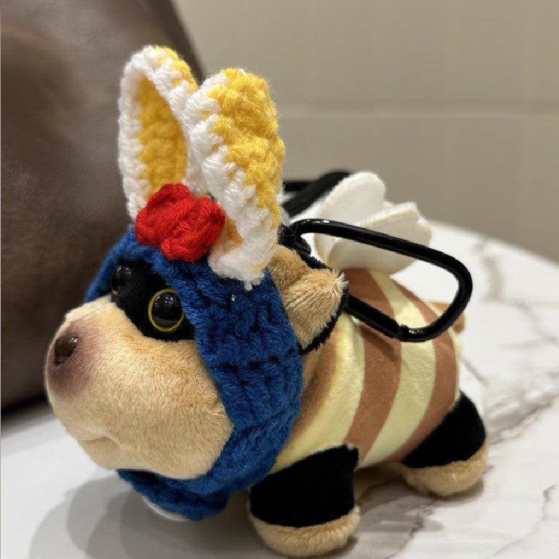 Plush dog charm with white hood-like headpiece and small chest decoration