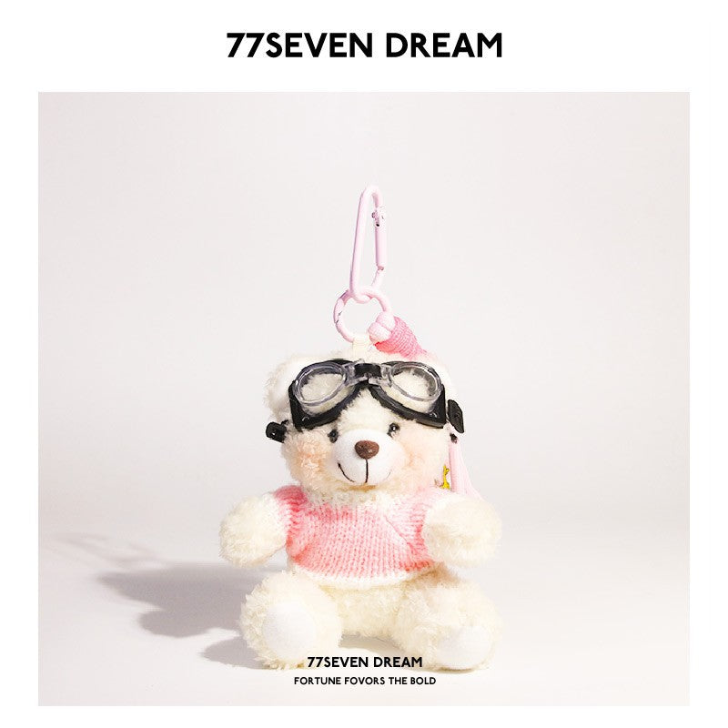 White bear plush keychain wearing pink-and-white knit sweater and goggles with pink hanging clip