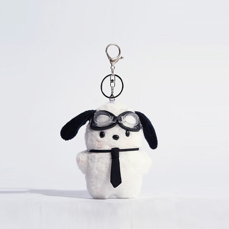 White plush dog keychain charm with black ears wearing clear goggles and a black necktie