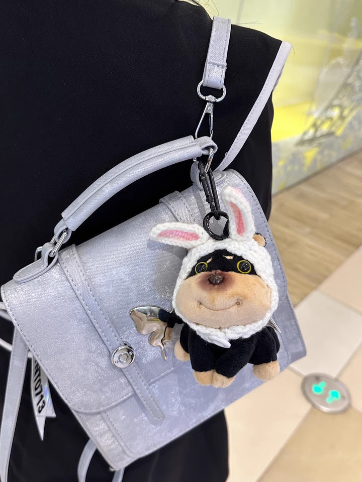 Plush dog charm with white rabbit-ear hood and pink inner ear details
