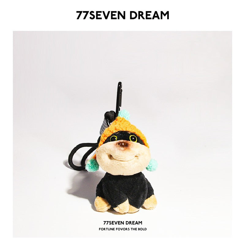 Small plush dog charm with orange knitted hat and blue pompoms, black clip attachment