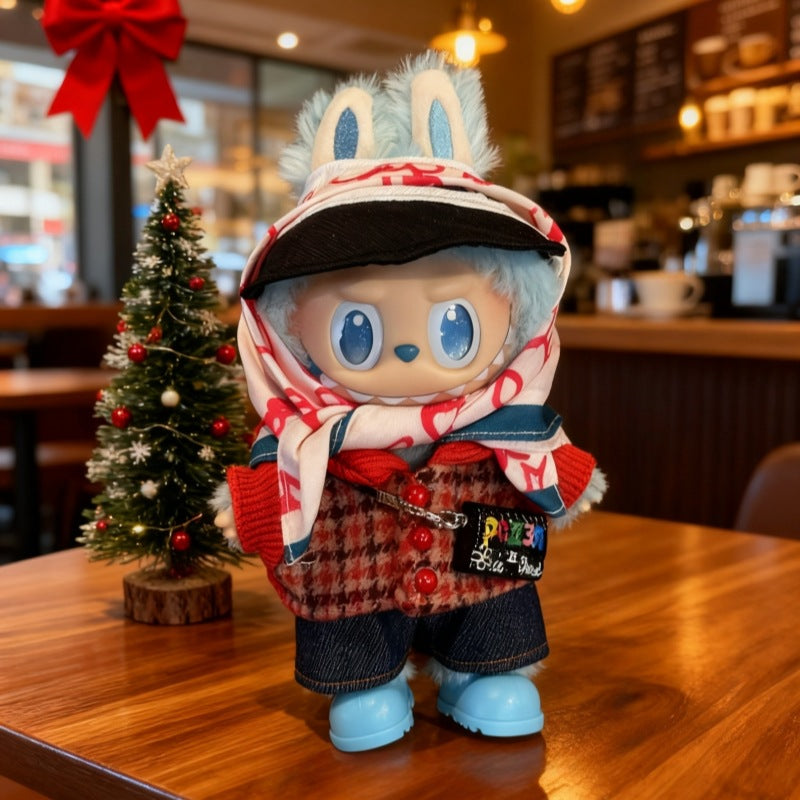 A ZoDoll Labubu plush with blue fur, big blue eyes, and bunny ears stands on a café table wearing the Labubu Doll Tweed Jacket Denim Shorts Scarf and Cap 4-Piece Set. A small Christmas tree nearby adds festive charm.
