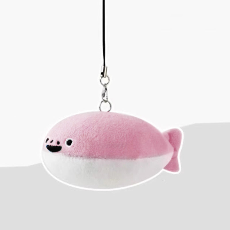 Pink and white fish-shaped plush keychain with smiling face, fin, tail, and black loop strap