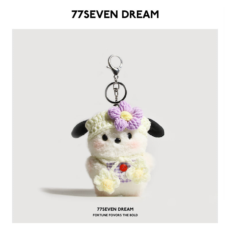 Kawaii dog plush keychain charm with purple gingham bib and purple flower hat detail on plain background