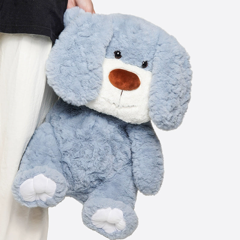Someone holds the ZEIO Charlie Dog Plush Toy 50cm—a soft, large stuffed pup with floppy ears—perfect for cuddling or as a charming nursery decoration, shown against a plain background.