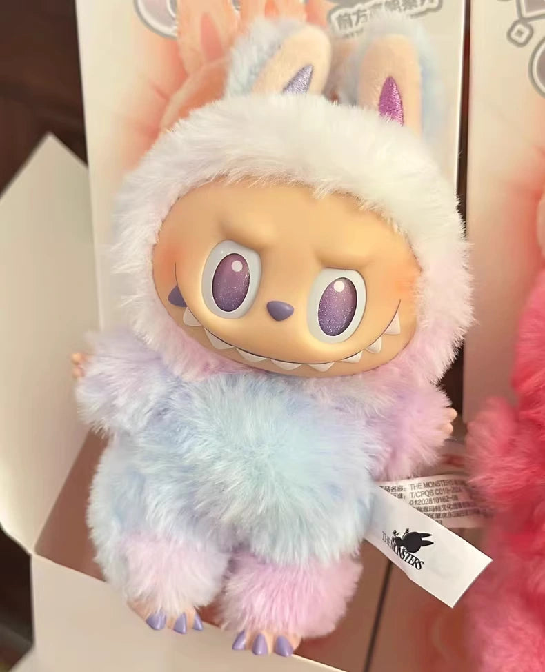 The POP MART Labubu "Luck" Plush Keychain from The Monsters "Big Into Energy" series features large eyes, sharp teeth, and a pastel bunny-eared hood in lavender, blue, and pink—perfect as a bag charm.