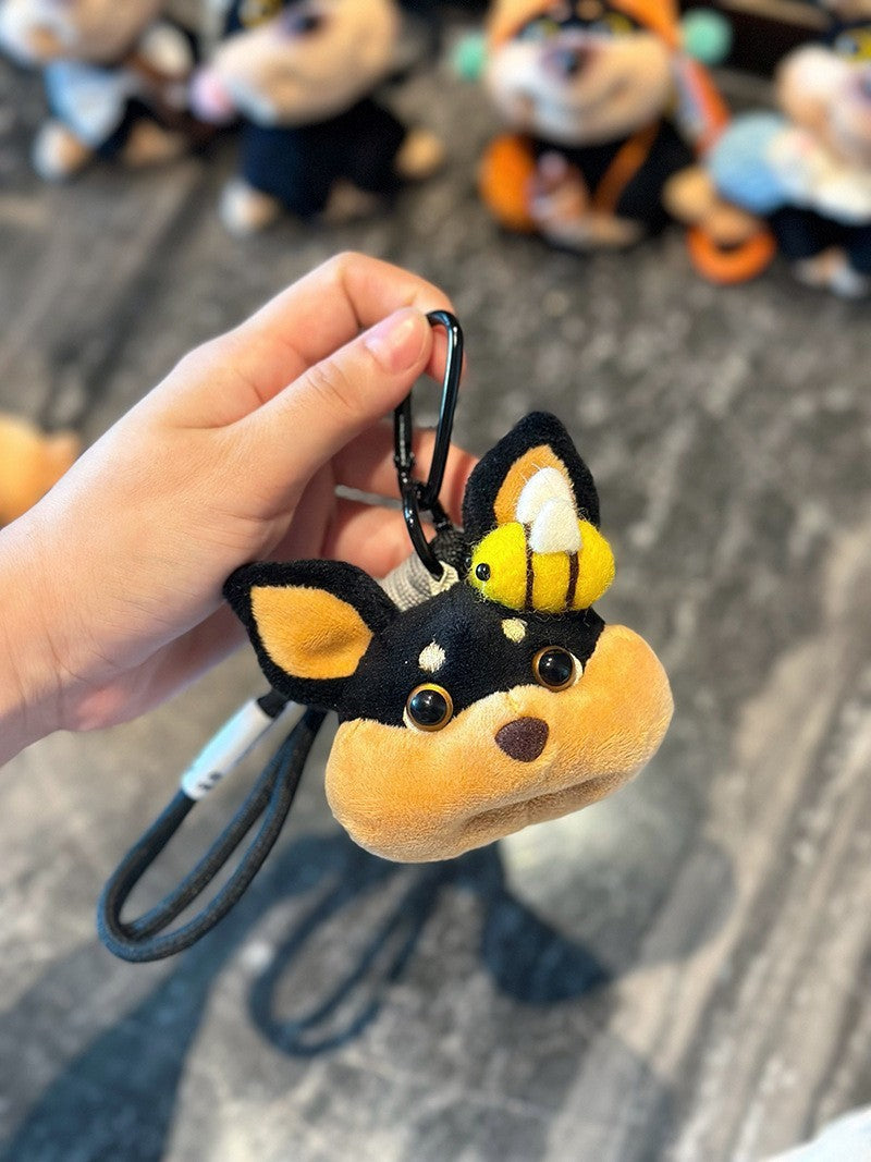 Close-up of dog-face plush charm with a bee figure perched on top of the head
