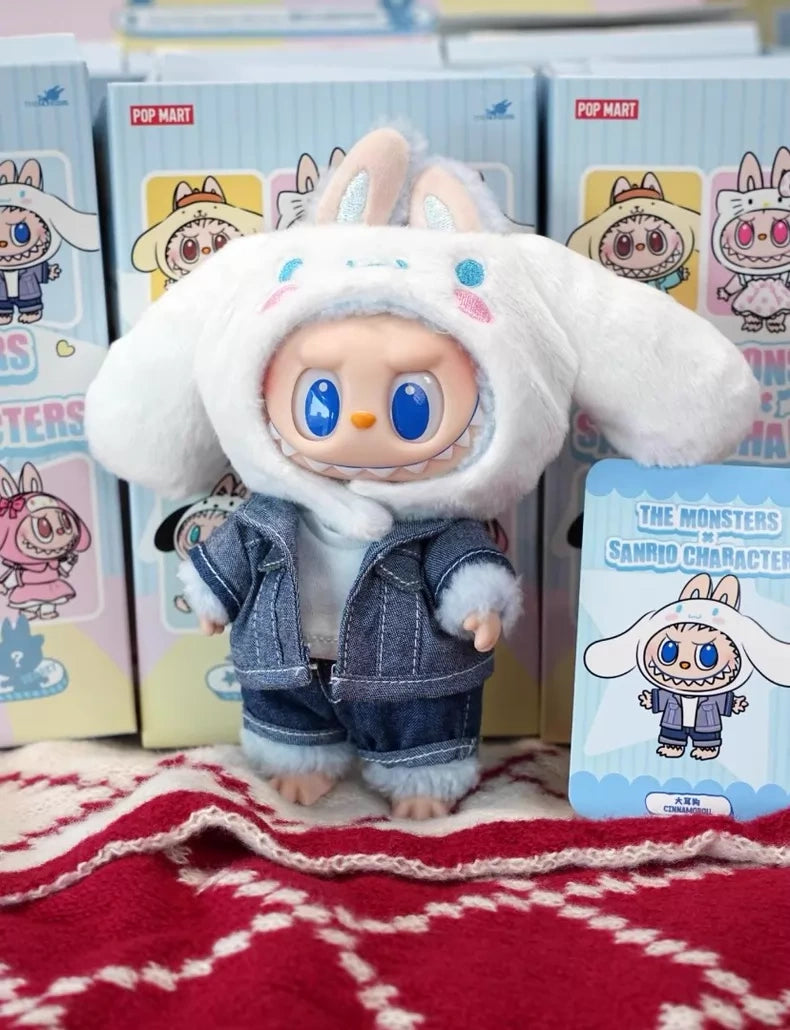 The POP MART LABUBU Hello Kitty and Friends Series Cinnamoroll Plush Pendant Figure features a doll with large blue eyes in a bunny hat and denim outfit, plus a matching character card—an adorable Sanrio collectible for kawaii fans.