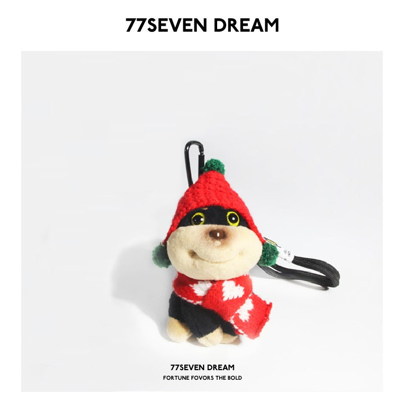 Festive plush dog charm in red Christmas hat with green trim and red patterned scarf