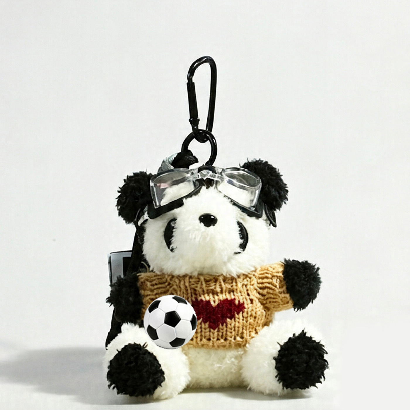 Panda plush bag charm wearing a khaki knit sweater with a heart motif on the chest and holding a soccer ball