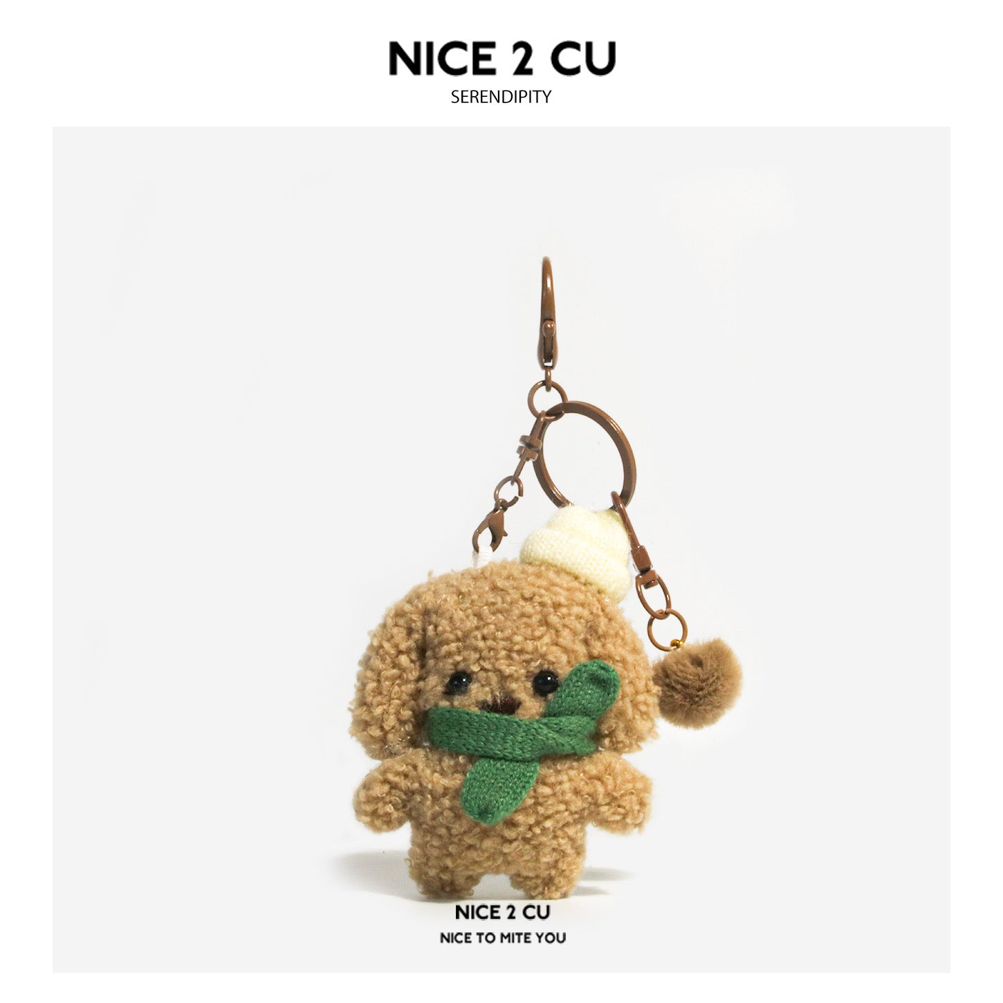 Curly brown plush dog keychain charm wearing a cream hat and green knitted scarf with rose-gold lobster clasp