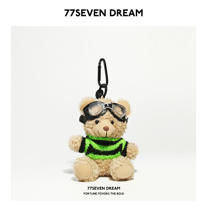 Tan bear plush keychain wearing black-and-neon-green striped knit sweater and black goggles