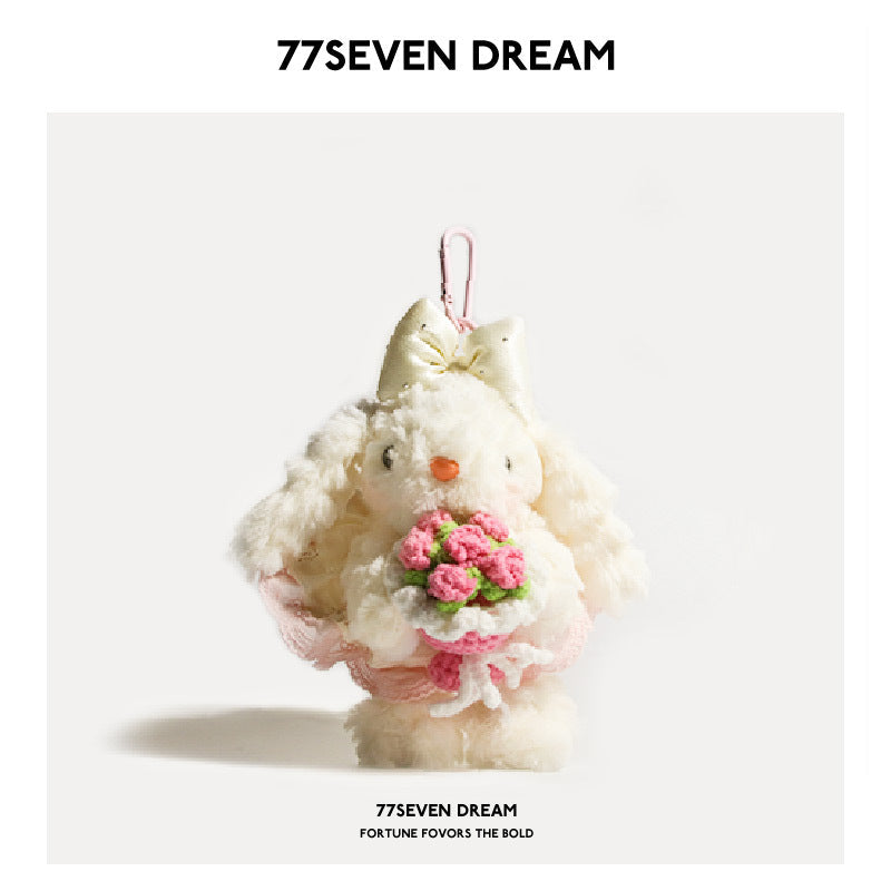 White bunny plush bag charm with pink bow and pink flower bouquet on light background
