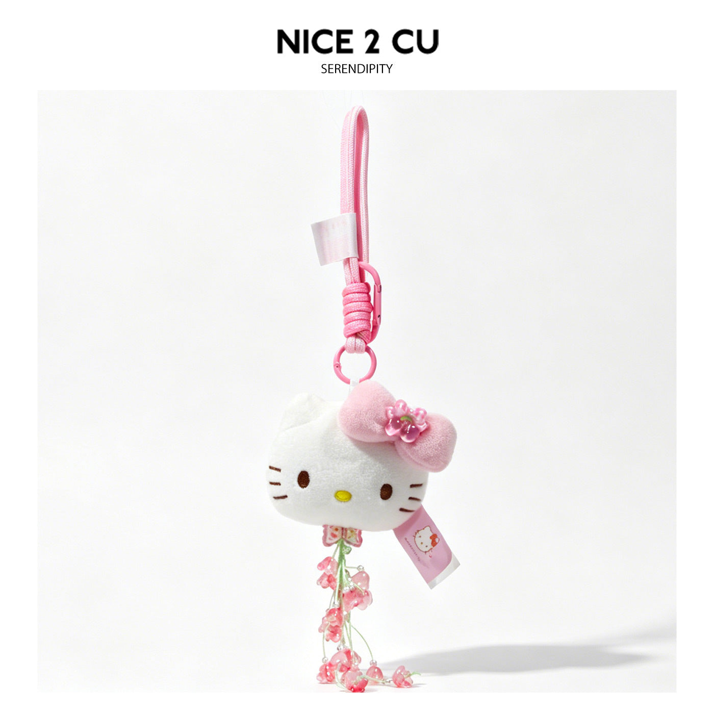 White cat-face plush charm keychain with pink bow accents and hanging pink floral ornaments on pink braided cord