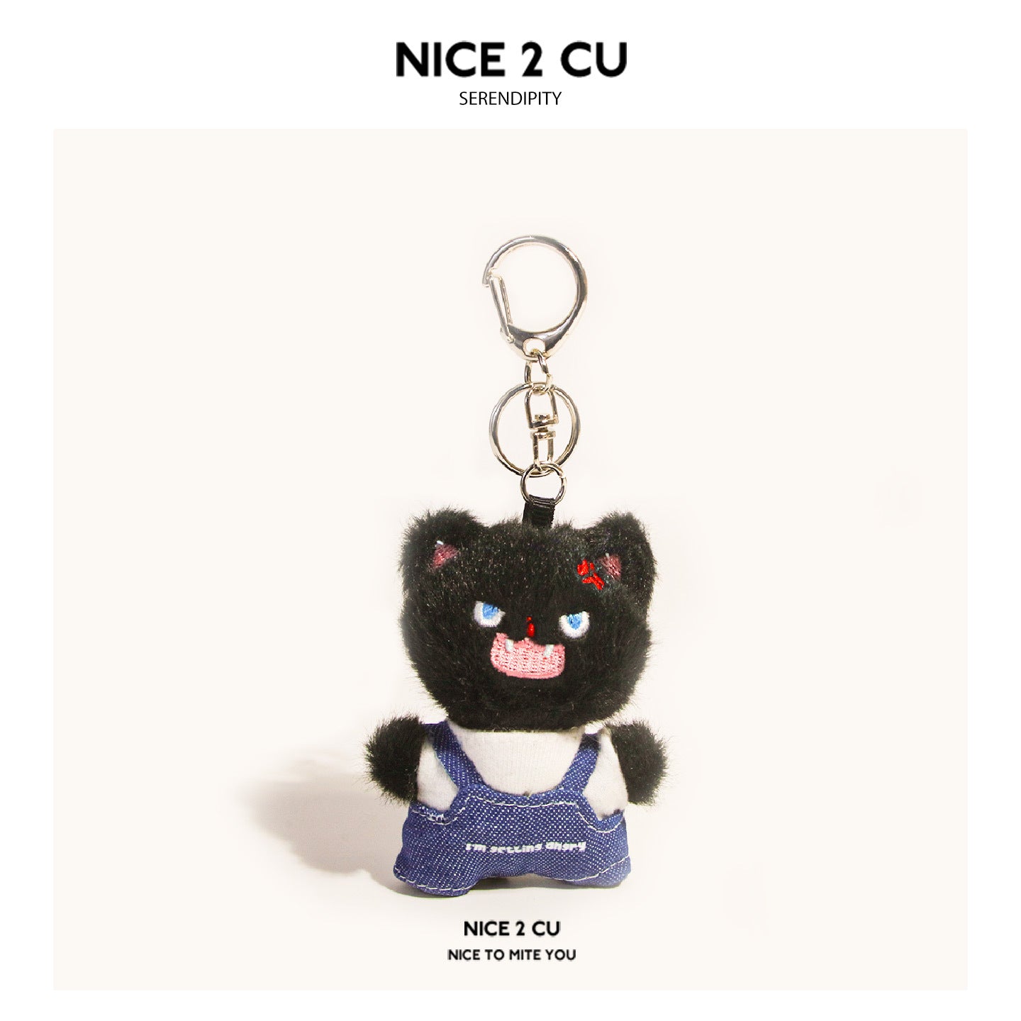 Black fluffy cat plush keychain wearing blue denim overalls over a white shirt with silver clasp