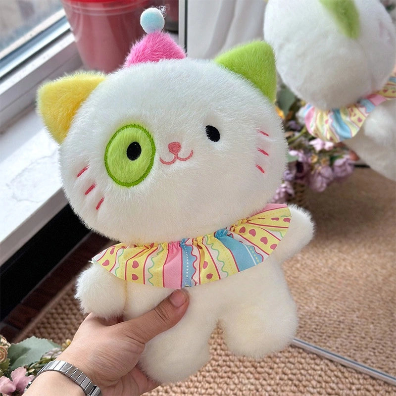 A person holds the ZoDoll Adorable 8.7" Cute Cat Plush Toy featuring a yellow ear, pastel ruffled collar, pink hat with blue pom-pom, and mirrored reflection. Eye color varies as the plush is shipped with random eye colors.