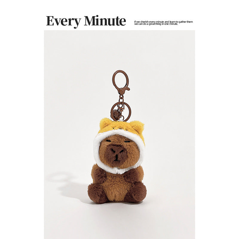Brown plush capybara keychain wearing a yellow bear hood with rounded ears and white face trim