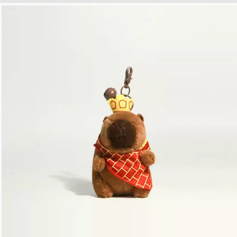 Brown plush capybara keychain wearing a crown and red patterned robe with metal keyring hardware