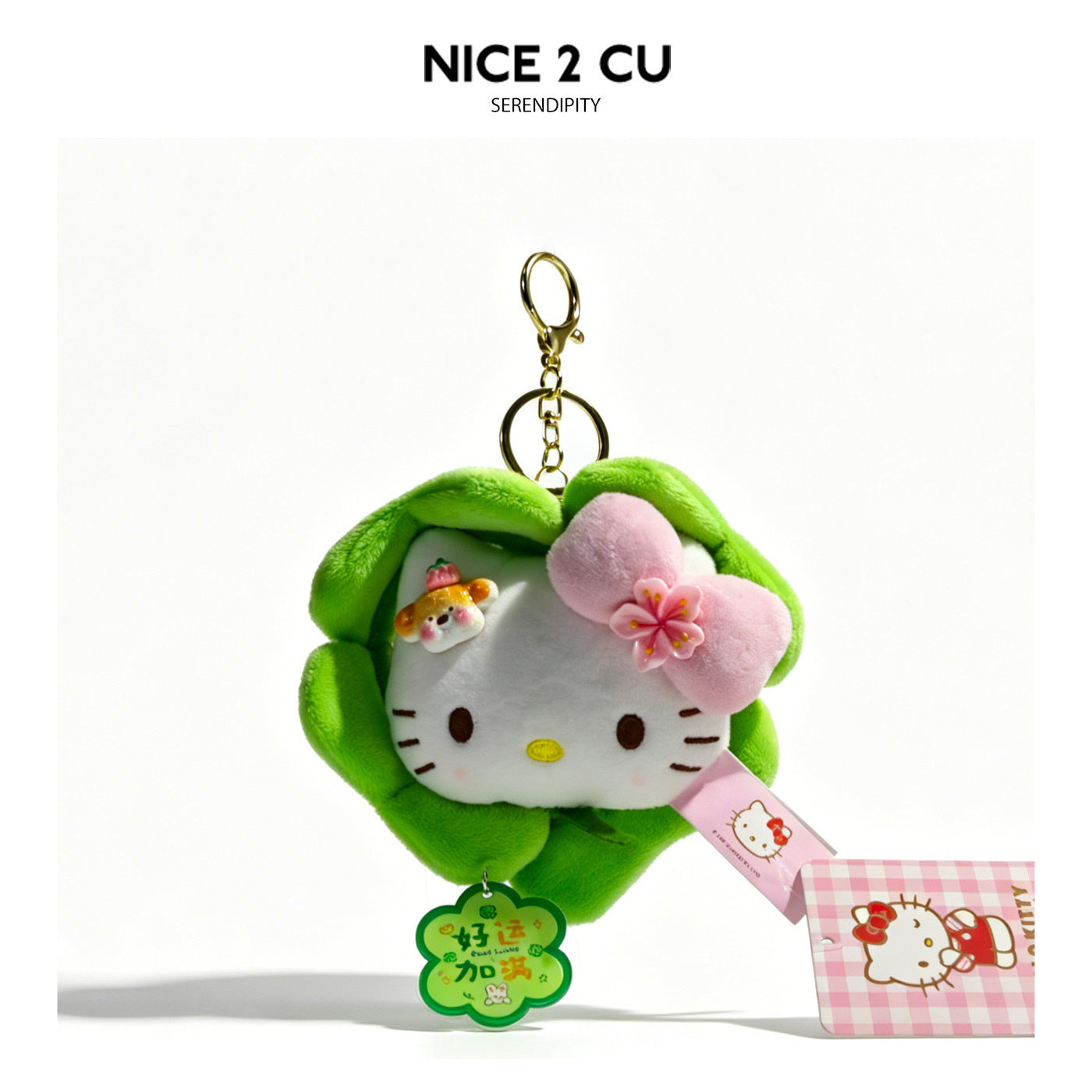 White cat plush keychain charm inside green four-leaf clover surround with pink bow, mini bear figurine, and lucky clover pen