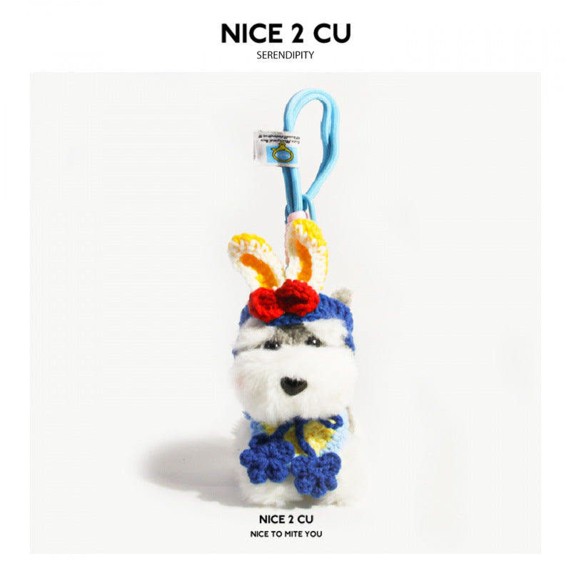Schnauzer plush charm with blue loop cord, bunny-ear crochet headpiece, and colorful blue floral neck accent