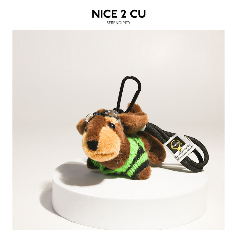 Plush dachshund charm in a green and black striped sweater with clear goggles and black clip