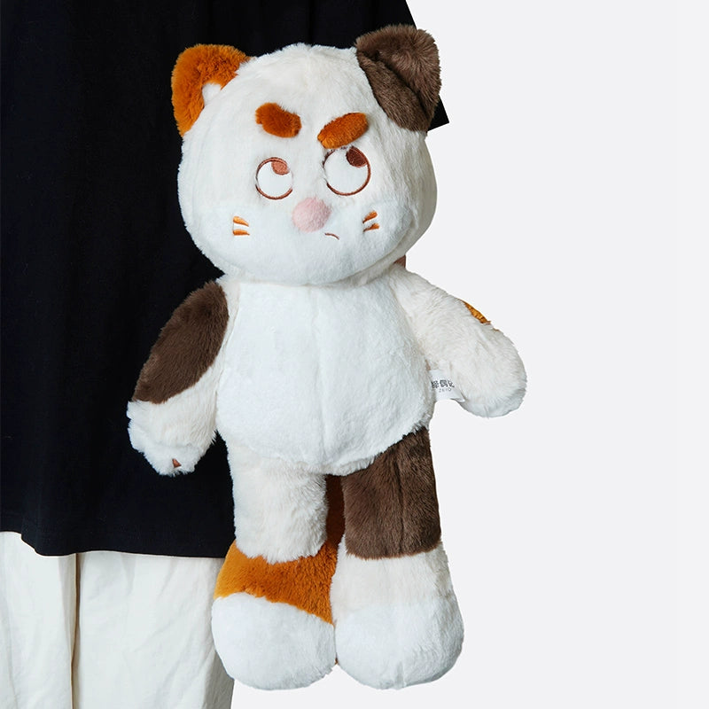 A person holds the ZEIO Cat Plush Toy 50cm—a large, soft stuffed cat with brown, white, and orange patches and an expressive face.