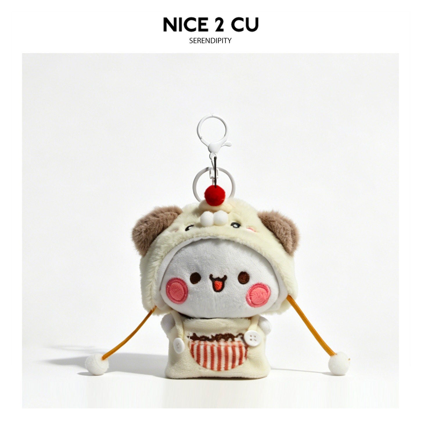 White kawaii plush animal keychain charm in a cream bear-hood outfit with orange cords and white pom-poms