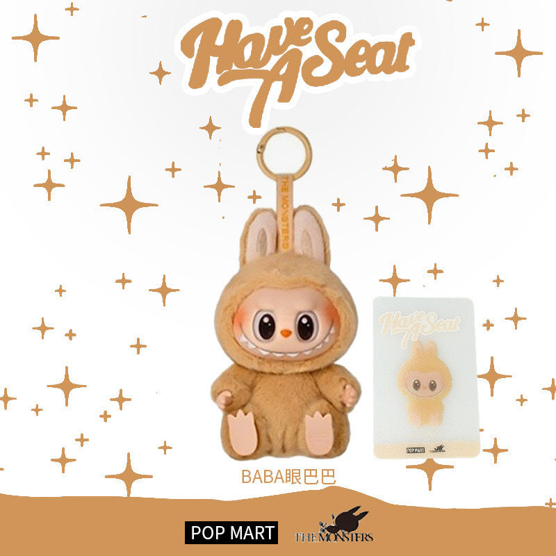 The Labubu “Baba” Plush Keychain – Have a Seat Series Brown Bunny by POP MART features a smiling plush in a bunny costume with matching packaging and the Labubu Have a Seat logo—a delightful collectible for fans.
