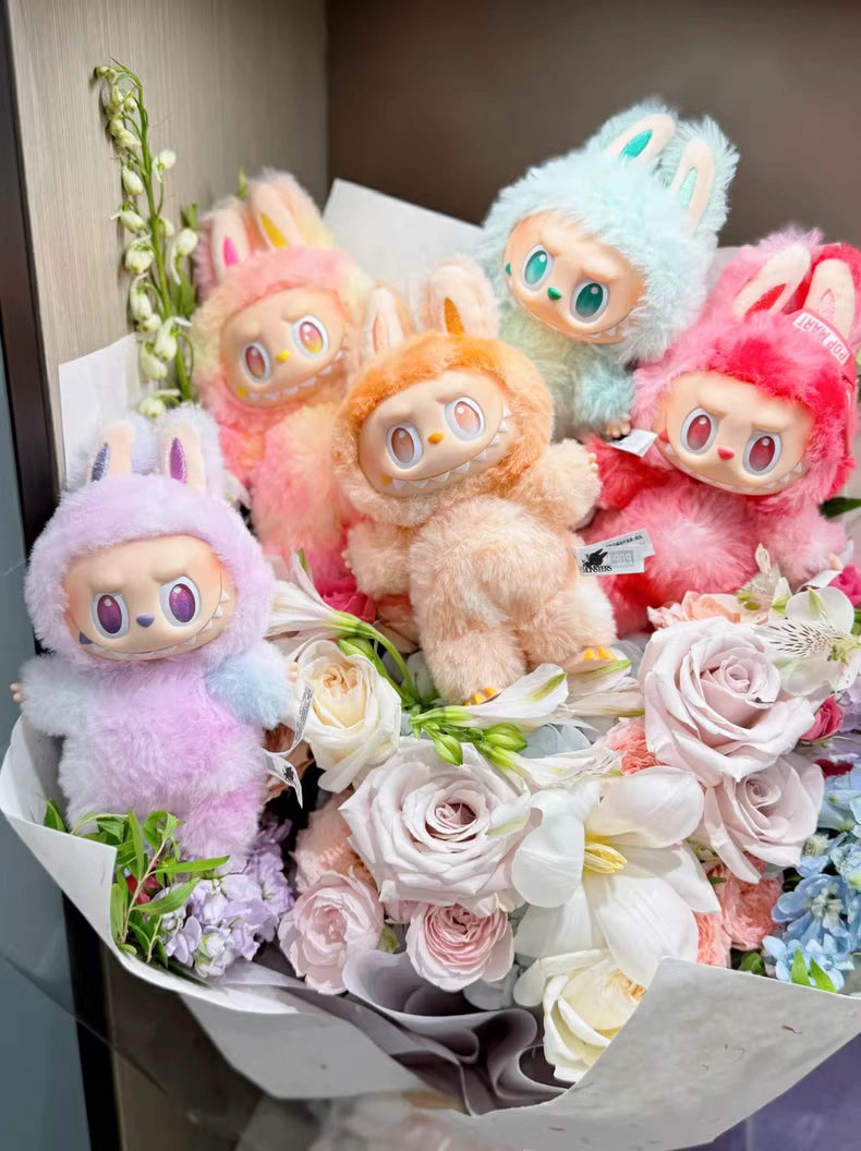 A pastel flower bouquet with five colorful bunny plush toys, a POP MART collectible, and a Labubu “Serenity” Plush Keychain – The Monsters “Big Into Energy” Series Mint Bunny Bag Charm nestled among the blooms.