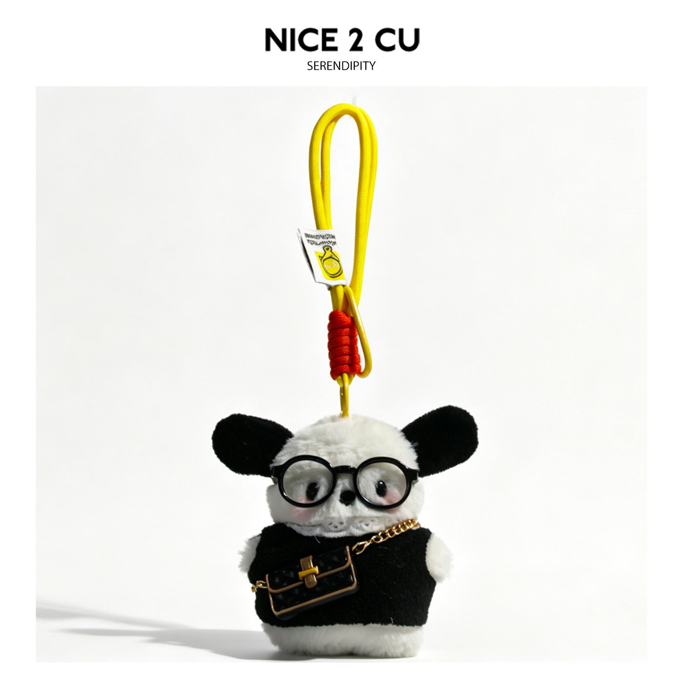 Plush dog bag charm in black outfit with round black glasses and miniature gold-chain crossbody bag on yellow loop cord