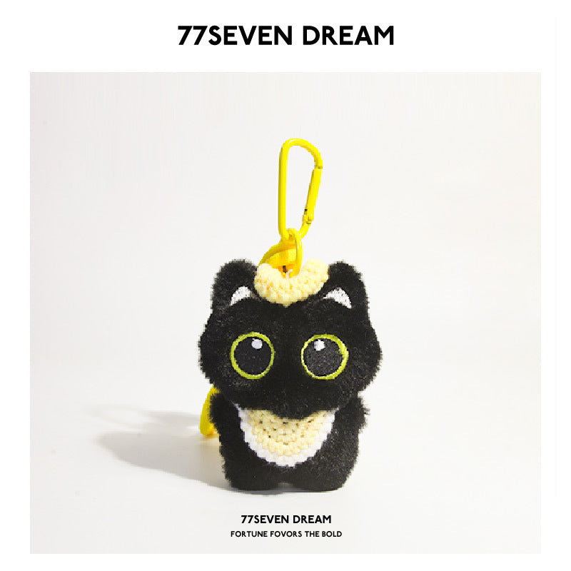 Black cat plush charm with large green eyes and yellow crocheted bib, yellow carabiner clip