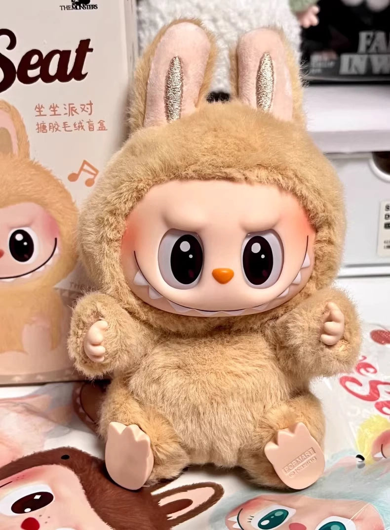 The Labubu “Baba” Plush Keychain – Have a Seat Series Brown Bunny by POP MART features a charming oversized-head plush in a fuzzy tan bunny suit, with big eyes and floppy ears, designed for collectible display or use as a keychain.
