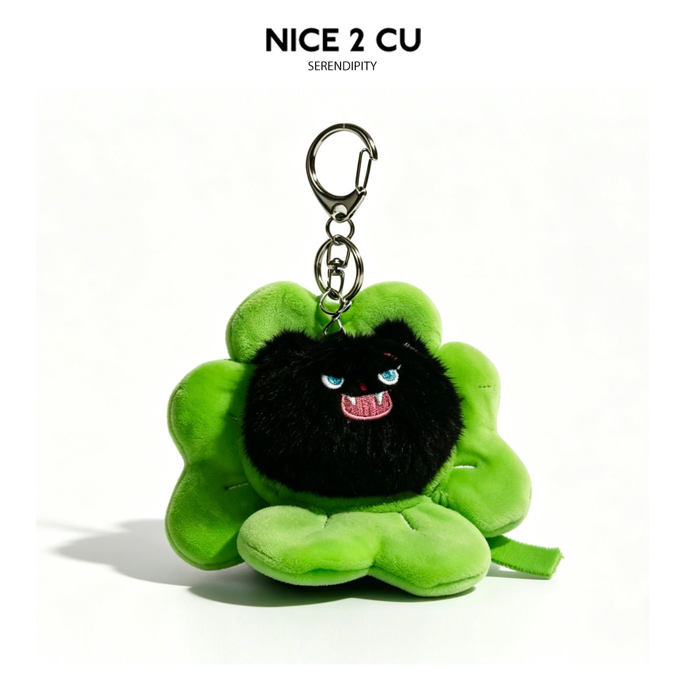 Black fluffy cat plush keychain charm inside a bright green four-leaf clover with embroidered blue eyes and fangs