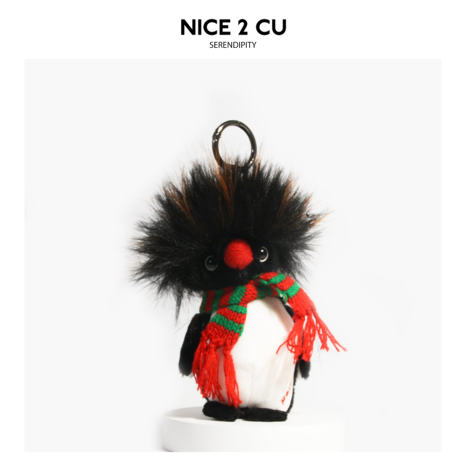 Fluffy penguin plush charm with red-and-green striped fringed scarf and metal hanging loop