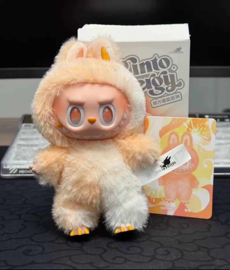 The POP MART Labubu “Happiness” Plush Keychain – The Monsters “Big Into Energy” Series Peach Bunny Bag Charm stands before a Pintooery box and card, making it a delightful collectible for any fan.