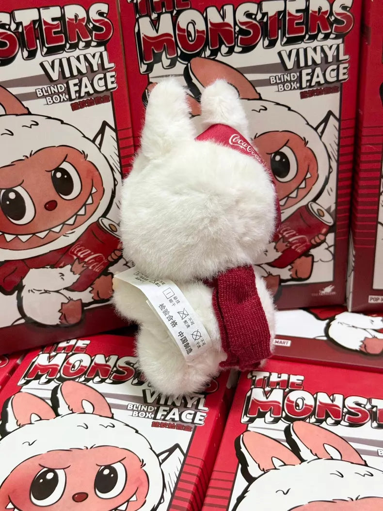 The Labubu Coca‑Cola Surprise Shake Plush Keychain – Christmas Bunny Edition by POP MART stands in front of red boxes, featuring a cute character with big eyes—an ideal Christmas collectible vinyl keychain.