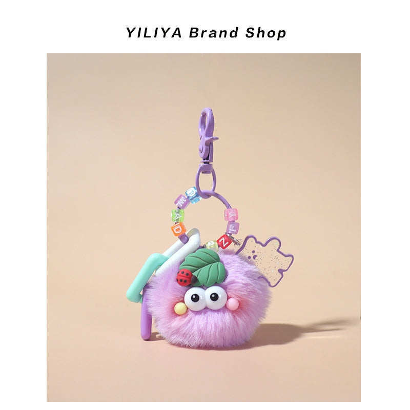 Purple fluffy pom-pom charm with purple small clip attachment, mint and purple plastic rings, glittery flower charm, and lady
