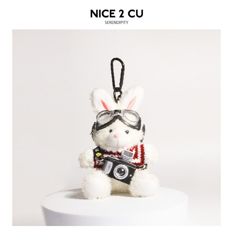 White plush rabbit keychain wearing maroon knit sweater with goggles and small camera charm