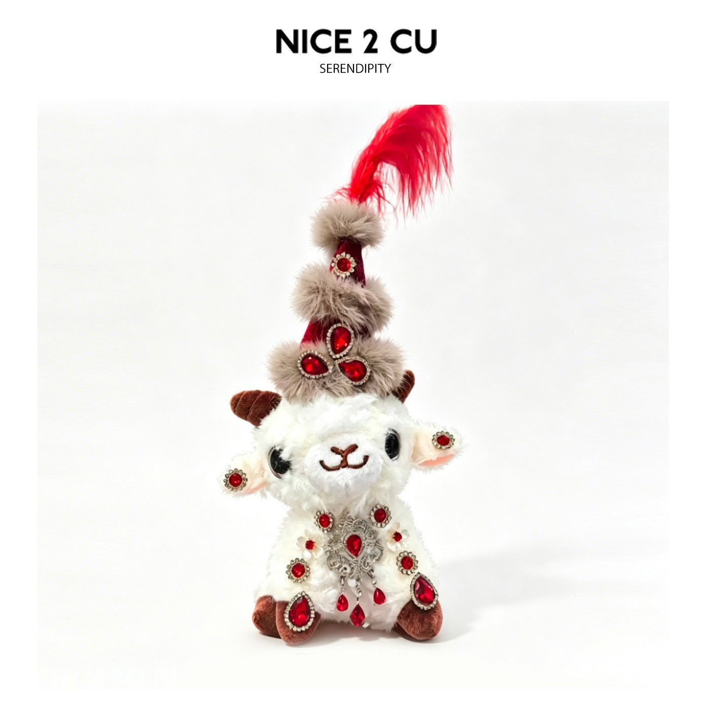 Plush lamb figurine with tall red feathered hat and heavy red gemstone embellishments on white outfit