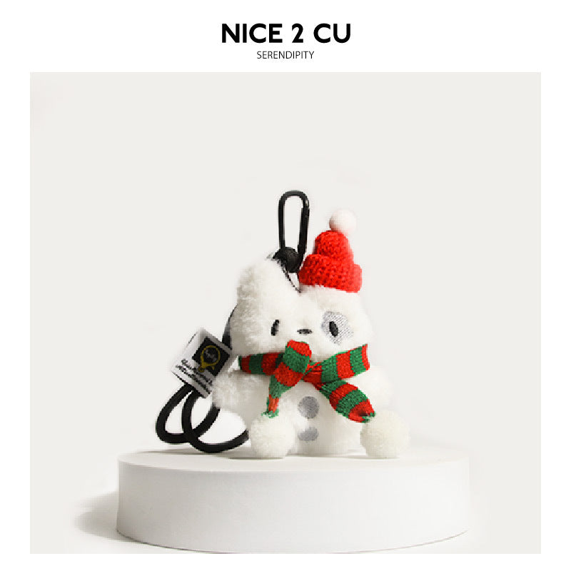 White dog plush keychain with a red knit hat and red-and-green striped scarf attached to a black carabiner